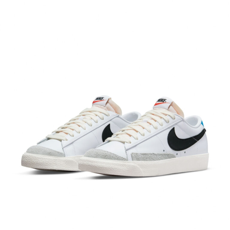کتونی اورجینال برند Nike مدل Blazer Low 77 رنگ سفید با جزئیات آبی و طوسی نمای جهت دار از بغل